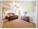 Spacious main bedroom featuring a wooden bed frame, dresser, and neutral-colored walls at 17975 W Willow Dr, Goodyear, AZ 85338