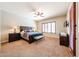 Spacious bedroom with a large bed, shuttered windows, and an abundance of natural light at 17975 W Willow Dr, Goodyear, AZ 85338