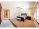 Large primary bedroom with sitting area, ceiling fan, and neutral carpet at 17975 W Willow Dr, Goodyear, AZ 85338