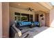 Covered patio with fan, comfortable seating, and view of the beautiful outdoor pool area at 17975 W Willow Dr, Goodyear, AZ 85338