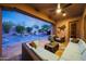 Comfortable covered patio overlooking a sparkling pool, enhanced with stone pavers and tasteful decor at 17975 W Willow Dr, Goodyear, AZ 85338