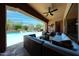 Covered patio with comfortable seating and a gorgeous view of the outdoor pool and landscaping at 17975 W Willow Dr, Goodyear, AZ 85338