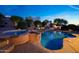 Inviting backyard with a large pool and spa, accented by lush landscaping and stone accents at 17975 W Willow Dr, Goodyear, AZ 85338