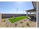 Backyard with a covered patio, outdoor dining, artificial turf, and drought-resistant landscaping at 18134 W Creedance Blvd, Surprise, AZ 85387