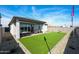 Artificial turf backyard with a covered patio, gravel perimeter, and privacy fence at 18134 W Creedance Blvd, Surprise, AZ 85387