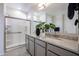 Contemporary bathroom featuring dual sinks, gray cabinetry, and a spacious shower at 18134 W Creedance Blvd, Surprise, AZ 85387