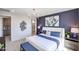 Bright bedroom with a blue accent wall, white bedding, and contemporary furnishings at 18134 W Creedance Blvd, Surprise, AZ 85387