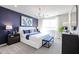 Stylish bedroom with a blue accent wall, white furniture, and elegant lighting at 18134 W Creedance Blvd, Surprise, AZ 85387