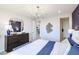 Well-lit bedroom featuring a blue accent wall, sleek dresser, and modern decor at 18134 W Creedance Blvd, Surprise, AZ 85387