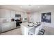 Bright kitchen featuring a large island with granite countertops, stainless steel appliances, and grey cabinets at 18134 W Creedance Blvd, Surprise, AZ 85387