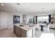 Open concept kitchen with granite countertops and a central island flowing into the dining and living areas at 18134 W Creedance Blvd, Surprise, AZ 85387