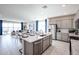Open concept kitchen with granite countertops and a central island flowing into the dining and living areas at 18134 W Creedance Blvd, Surprise, AZ 85387