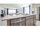 Open concept kitchen with granite countertops and a central island flowing into the dining and living areas at 18134 W Creedance Blvd, Surprise, AZ 85387