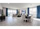 Open-concept living room and dining area with tile floors, large windows, and contemporary furnishings at 18134 W Creedance Blvd, Surprise, AZ 85387