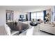 Open-concept living room and dining area with tile floors, large windows, and contemporary furnishings at 18134 W Creedance Blvd, Surprise, AZ 85387