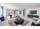 Open-concept living room with dining area and modern decor featuring tile floors and neutral tones at 18134 W Creedance Blvd, Surprise, AZ 85387