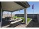 Covered patio has outdoor seating and dining with views of the artificial turf backyard at 18134 W Creedance Blvd, Surprise, AZ 85387