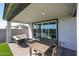 Covered patio is furnished with a dining table and outdoor seating overlooking artificial turf at 18134 W Creedance Blvd, Surprise, AZ 85387