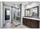 Modern bathroom with a glass-enclosed shower, double vanity, granite countertops, and access to a walk-in closet at 18562 N 94Th St, Scottsdale, AZ 85255