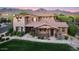 Charming two-story home showcasing stone accents, a covered porch, and a well-maintained lawn set against a mountain backdrop at 18562 N 94Th St, Scottsdale, AZ 85255
