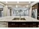 Close-up of the kitchen island featuring granite countertops and a stainless steel sink, leading into a spacious living area at 18562 N 94Th St, Scottsdale, AZ 85255