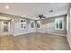 Bright living room with wood tile floors, neutral walls, stylish lighting, and multiple windows with shutters at 18562 N 94Th St, Scottsdale, AZ 85255