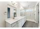 Bright bathroom with double vanity, frameless glass shower, and neutral grey wood flooring at 18931 W Crescent Way, Buckeye, AZ 85326