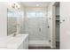 Bright bathroom with frameless glass shower, neutral grey wood flooring, and white vanity at 18931 W Crescent Way, Buckeye, AZ 85326