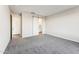 Spacious bedroom with gray carpet, a ceiling light, and a sliding barn door leading to a bathroom at 18931 W Crescent Way, Buckeye, AZ 85326