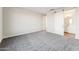 Spacious bedroom with gray carpet, a ceiling light, and a sliding barn door leading to a bathroom at 18931 W Crescent Way, Buckeye, AZ 85326