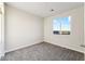 Neutral bedroom with plush gray carpeting and a large window overlooking the outdoor scenery at 18931 W Crescent Way, Buckeye, AZ 85326