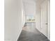 Bright and airy hallway with modern gray wood flooring, leading to a living area with large, scenic windows at 18931 W Crescent Way, Buckeye, AZ 85326
