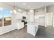 Bright kitchen featuring stainless steel appliances, grey wood flooring, and a center island with a sink at 18931 W Crescent Way, Buckeye, AZ 85326