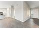 Open-concept living space with gray wood floors, flowing into a kitchen with white cabinets and modern appliances at 18931 W Crescent Way, Buckeye, AZ 85326