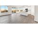 Bright, open-concept living space with sleek gray flooring, showcasing the modern kitchen with a central island at 18931 W Crescent Way, Buckeye, AZ 85326