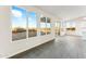 Spacious living area with large windows offering scenic outdoor views, complemented by modern gray flooring and sleek finishes at 18931 W Crescent Way, Buckeye, AZ 85326