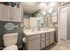 Bathroom with double sinks, white cabinets, and coastal-themed decorations at 20251 W Madison St, Buckeye, AZ 85326