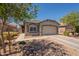 Charming single-story home featuring a two-car garage, desert landscaping, and inviting entryway at 20251 W Madison St, Buckeye, AZ 85326