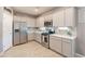Modern kitchen with stainless steel appliances, white cabinets, tile backsplash, and ample counter space at 20251 W Madison St, Buckeye, AZ 85326