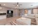 Bright and airy living room featuring a ceiling fan, tiled floors, and comfortable sectional at 20251 W Madison St, Buckeye, AZ 85326