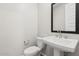 Clean, minimalist powder bathroom with a pedestal sink and modern fixtures at 21047 N 58Th Way, Phoenix, AZ 85054