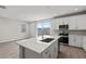 Open kitchen with quartz countertops, island with sink, and stainless steel appliances at 21047 N 58Th Way, Phoenix, AZ 85054