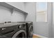 Laundry room featuring modern appliances, storage, and a bright window at 21047 N 58Th Way, Phoenix, AZ 85054