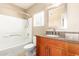 Bathroom features shower over tub and vanity with granite counter and wood cabinets at 2134 E Broadway Rd # 2030, Tempe, AZ 85282