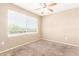 This carpeted bedroom features a ceiling fan and a bright window with neighborhood views at 2134 E Broadway Rd # 2030, Tempe, AZ 85282
