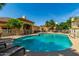 Resort-style pool with palm trees, lounge chairs, and clubhouse for relaxation and enjoyment at 2134 E Broadway Rd # 2030, Tempe, AZ 85282