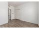 Bedroom with sliding closet doors, neutral paint, wood-look floors, and modern ceiling fan at 21655 N 36Th Ave # 131, Glendale, AZ 85308