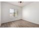 Bedroom with wood-look floors, modern ceiling fan, and large window with blinds at 21655 N 36Th Ave # 131, Glendale, AZ 85308