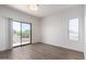 Bright bedroom with sliding glass door to balcony, gray wood-look flooring and modern lighting at 21655 N 36Th Ave # 131, Glendale, AZ 85308