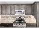 Modern kitchen with stainless steel appliances, granite countertops, and dark wood cabinets at 21655 N 36Th Ave # 131, Glendale, AZ 85308